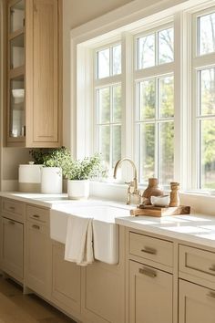 a white kitchen with wooden cabinets and windows