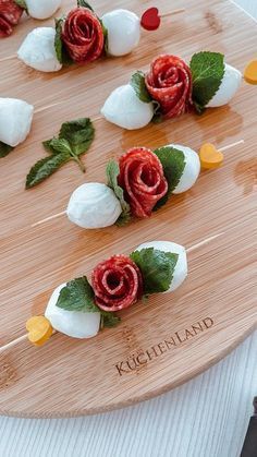 flowers are arranged on skewers made from marshmallows and rose petals