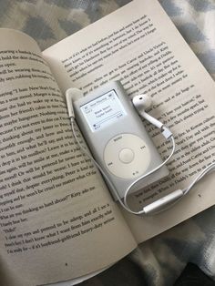 an apple ipod sitting on top of an open book