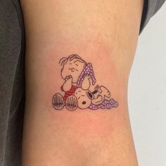 a woman's leg with a small tattoo of a cartoon character and a dog on it