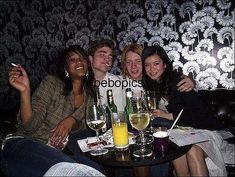 four people sitting at a table with drinks