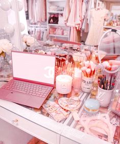 a laptop computer sitting on top of a white desk covered in makeup and personal care items