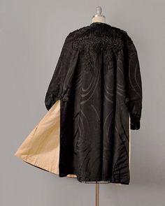 "This lavishly embellished statement coat hails from the late 1800's, and is made from the most extraordinary materials. The exterior is made from an incredible silk moiré jacquard -- with the signature grain effect of moiré, but with shimmery satiny swirls spread across its surface. The shoulders and chest are lavishly adorned with black gelatin sequins, real jet beading, heavy silk braid, and delicate net (with tiny hints of a spider's web motif). This exquisite hand-work cascades down the bac Elegant Formal Outerwear With Historical Design, Silk Long Coat For Evening, Elegant Silk Outerwear With Embroidery, Embroidered Silk Evening Outerwear, Elegant Embroidered Silk Outerwear, Victorian Long Sleeve Evening Outerwear, Elegant Embroidered Evening Outerwear, Victorian Jacket, Broadway Costumes