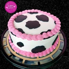 two tiered cake decorated with pink and black polka dots