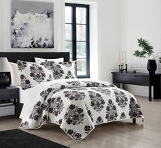 a white bed with black and red flowers on it