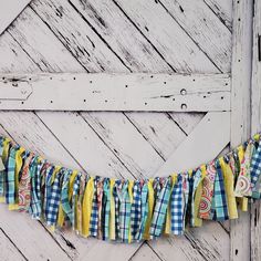 a blue and white checkered fabric banner hanging on a barn door with wooden planks