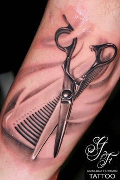 a tattoo with scissors and comb on it