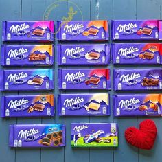 six bars of milka chocolate next to a red ball of yarn