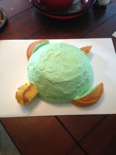 a cake shaped like a turtle sitting on top of a white plate with green frosting