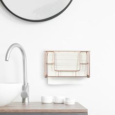 a bathroom with a sink, mirror and soap dispenser on the wall