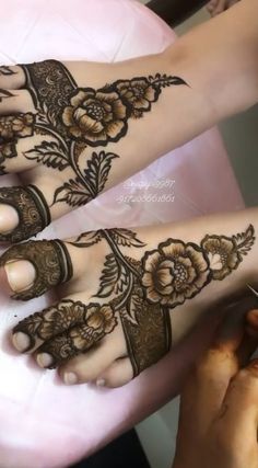 two feet with henna tattoos on them