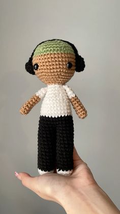 a small crocheted doll is held in the palm of someone's hand