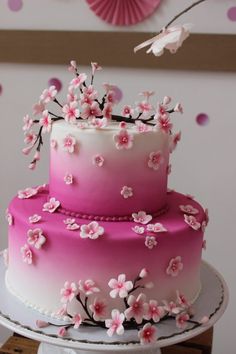 a pink and white cake with flowers on it