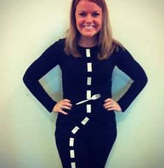 a woman standing in front of a white wall with her hands on her hips and smiling