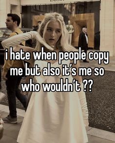 a girl in white dress standing on the sidewalk with her hand over her shoulder and texting i hate when people copy me but also it's me