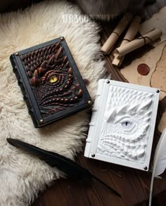 a book sitting on top of a white rug next to a feather quill pen