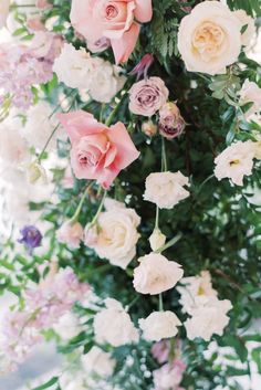 pink and white flowers are hanging from the ceiling