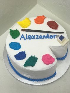 there is a cake that has been decorated with different colors and brush on top of it