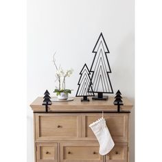 a wooden dresser topped with christmas decorations and a stocking hanging on it's side