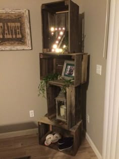 a shelf made out of pallets with some lights on top and pictures in the bottom