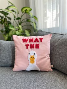 a pink pillow that says, what the duck?