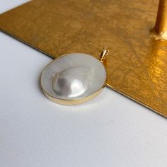 Estate/ vintage 14KT yellow gold genuine, Mabe Blister pearl omega/ pearl enhancer slide. Fits up to a 5mm depending upon the necklace/omega ORopens to fits (any size) in the space between your pearls or other beaded necklaces. Stamped / Hallmarked 14KT/585 14KT gold bezel encased Mabe pearl Measures: 45mm x 35mm Fits 5mm depending upon how flat your chain may be Weight: 17.50 grams Excellent condition No chain included Oval Pearl Pendant, Classic Yellow Gold Mother Of Pearl Jewelry, Classic Mother Of Pearl Jewelry In Yellow Gold, Classic Yellow Gold Jewelry With Mother Of Pearl, Elegant Large Pendant Mother Of Pearl Jewelry, Classic High Luster Pendant Jewelry, Classic Pearl Charm Jewelry In Mother Of Pearl, Classic Mother Of Pearl Jewelry With Pearl Charm, Oval Akoya Pearl Gold Jewelry