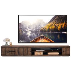 a large flat screen tv sitting on top of a wooden entertainment center