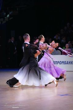 two people dancing on a dance floor with an audience in the background