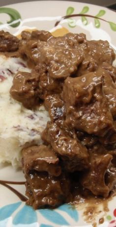 a close up of a plate of food with meat and mashed potatoes on it