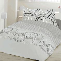 a bed with white and black comforters in a room