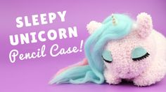 a stuffed unicorn laying on top of a purple background with the words sleepy unicorn pencil case