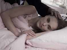 a woman laying on top of a bed next to a man