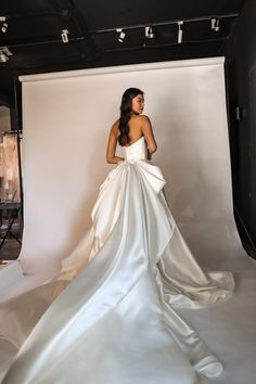 a woman standing in front of a white backdrop