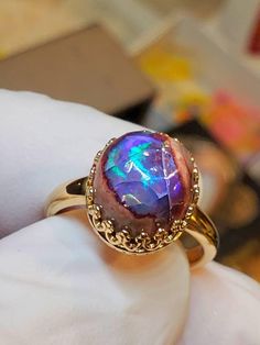 Beautiful Mexican blue and purple cantera fire opal  10x12mm, 5.8cts. Good fire surrounded by tan colored matrix, mounted on a 14k solid gold gallery style bezel ring Gold Opal Ring Oval Cabochon, Handmade Gold Opal Ring, Opal Oval Cabochon Ring For Promises, Opal Oval Cabochon Promise Ring, Oval Cabochon Opal Promise Ring, Handmade Opal Promise Ring, Yellow Gold Opal Ring With Cabochon, Iridescent Opal Ring With Gemstone, Iridescent Opal Ring As A Gift