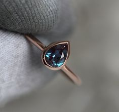 a ring with a blue topaz stone on it's side, sitting on a white cloth