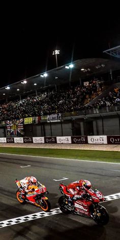 three motorcyclists racing on a race track at night