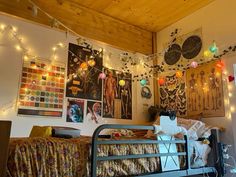 a bedroom with lights strung from the ceiling and pictures on the wall above it,