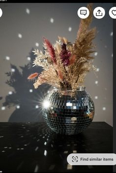 a disco ball vase with dried flowers in it