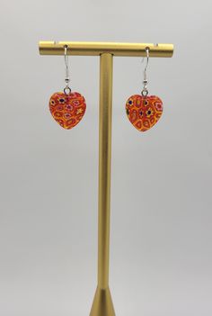 These are beautiful vintage Murano glass millefiori heart earrings made in Italy. ATTRIBUTES - Hooks for pierced ears - Millefiori is Italian for "thousand flowers", and Murano is famous for perfecting the art of using glass flower rods in their jewelry - Hooks are marked 925 for sterling silver - Features white and yellow flower rods in an orangey red heart - Minor wear from gentle use - beautiful earrings  MEASUREMENTS - 0.68" wide x 0.68" long, 1.43" drop CONDITION - Excellent GENTLY USED vintage condition with minor wear MORE BEAUTIFUL EARRINGS - https://www.etsy.com/shop/SiftedandRefined?section_id=32269566 BACK TO OUR STOREFRONT - https://www.etsy.com/shop/SiftedandRefined SPECIAL NOTE - Props such as trays, display stands, jewelry boxes, rulers, or coins are not included SHIPPING - Elegant Multicolor Earrings For Valentine's Day, Elegant Multicolor Heart Earrings For Gift, Elegant Multicolor Heart Earrings Gift, Multicolor Heart-shaped Pierced Jewelry, Red Round Heart Earrings For Gift, Red Heart Earrings For Gift, Vintage Glass Earrings For Gift, Heart-shaped Orange Jewelry For Gift, Orange Heart-shaped Jewelry Gift