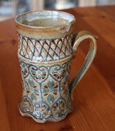 a ceramic cup sitting on top of a wooden table