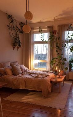 a bed room with a neatly made bed and lots of plants on the windowsill