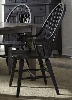 a dining room table with two chairs and a cabinet in the backround area