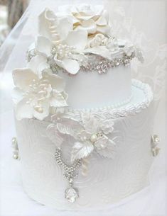 a wedding cake decorated with flowers and pearls