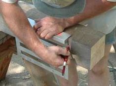 a man working on a piece of wood with a hammer and sawtoothing tool