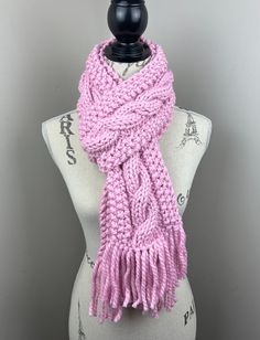 a pink knitted scarf sitting on top of a mannequin