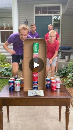 a group of men standing around a table with cans on it