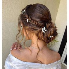 a woman wearing a white dress with flowers in her hair