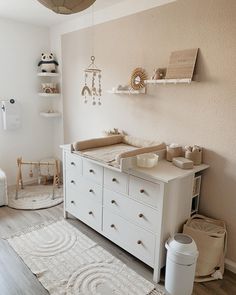 a baby's room with white furniture and accessories