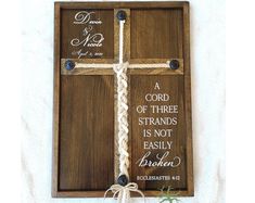 a wooden cross with a rope tied around it and a bible verse on the front