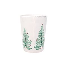 a white cup with green trees painted on it